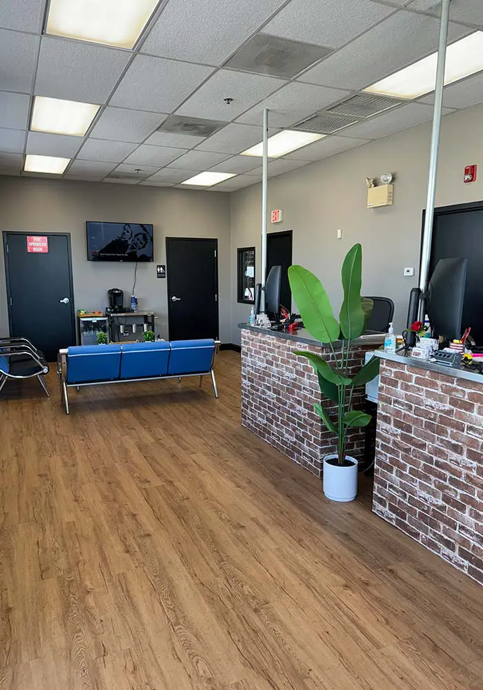 cj-automotive-and-tire-customer-waiting-room Interior shot of a C& Automotive & Tire waiting room and checkout area, featuring comfortable seating, TV, coffee station and bathrooms
