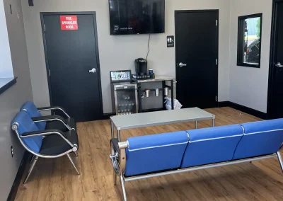 Customer waiting area at C&J Automotive & Tire of Lionville with chairs, a coffee station and a wall-mounted TV.