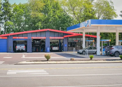 Street view of C&J Automotive service center next to a Gulf gas station, with open bays for tires, oil changes, brakes and batteries and state inspections.
