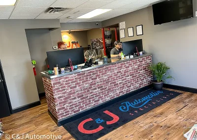 Front desk at the Upper Chichester C&J Automotive Specialists location with two staff members assisting customers.
