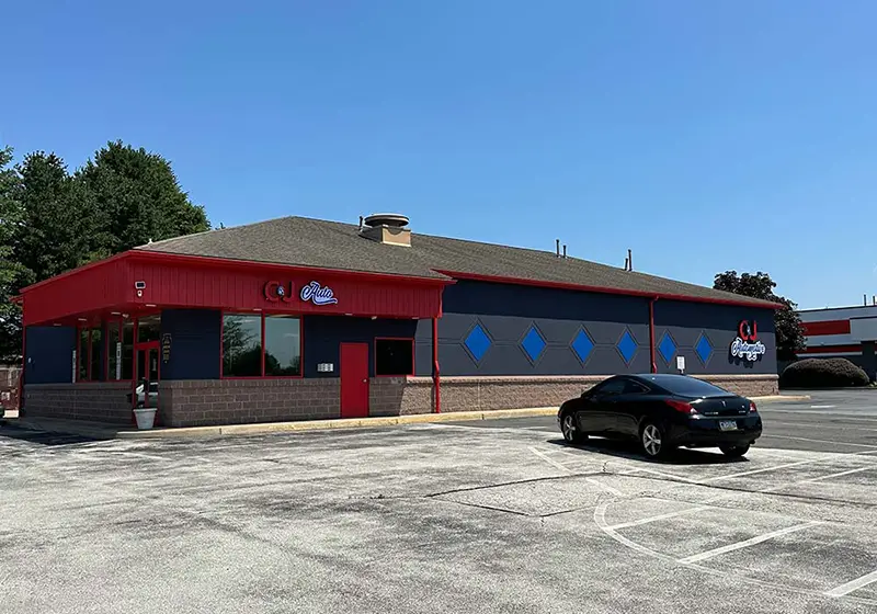 C&J Auto in Lionville, a navy blue and red auto repair building with diamond-shaped wall accents, branded storefront signs, and a spacious parking lot.